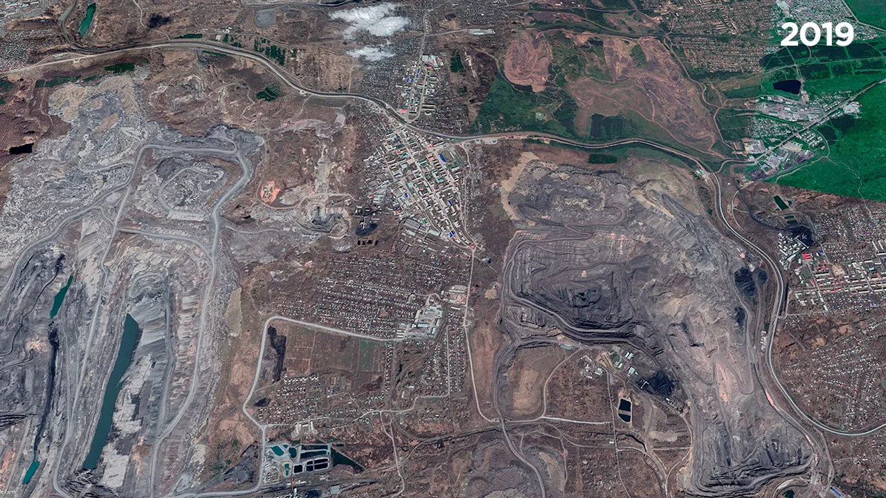 Satellite image of Kiselevsk showing open pits and waste dumps surrounding residential areas