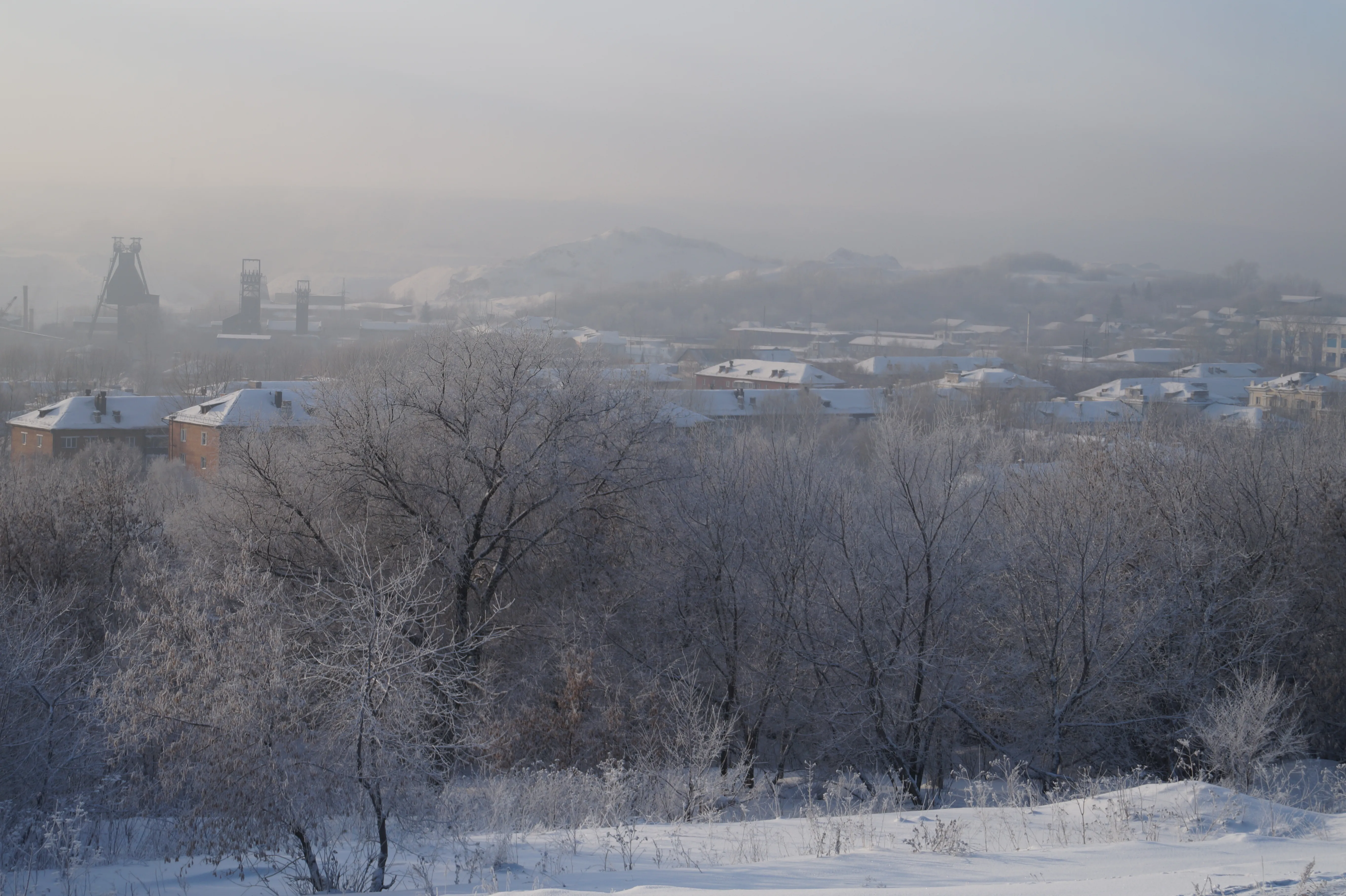 Winter industrial landscape in Kiselyovsk beside residential homes