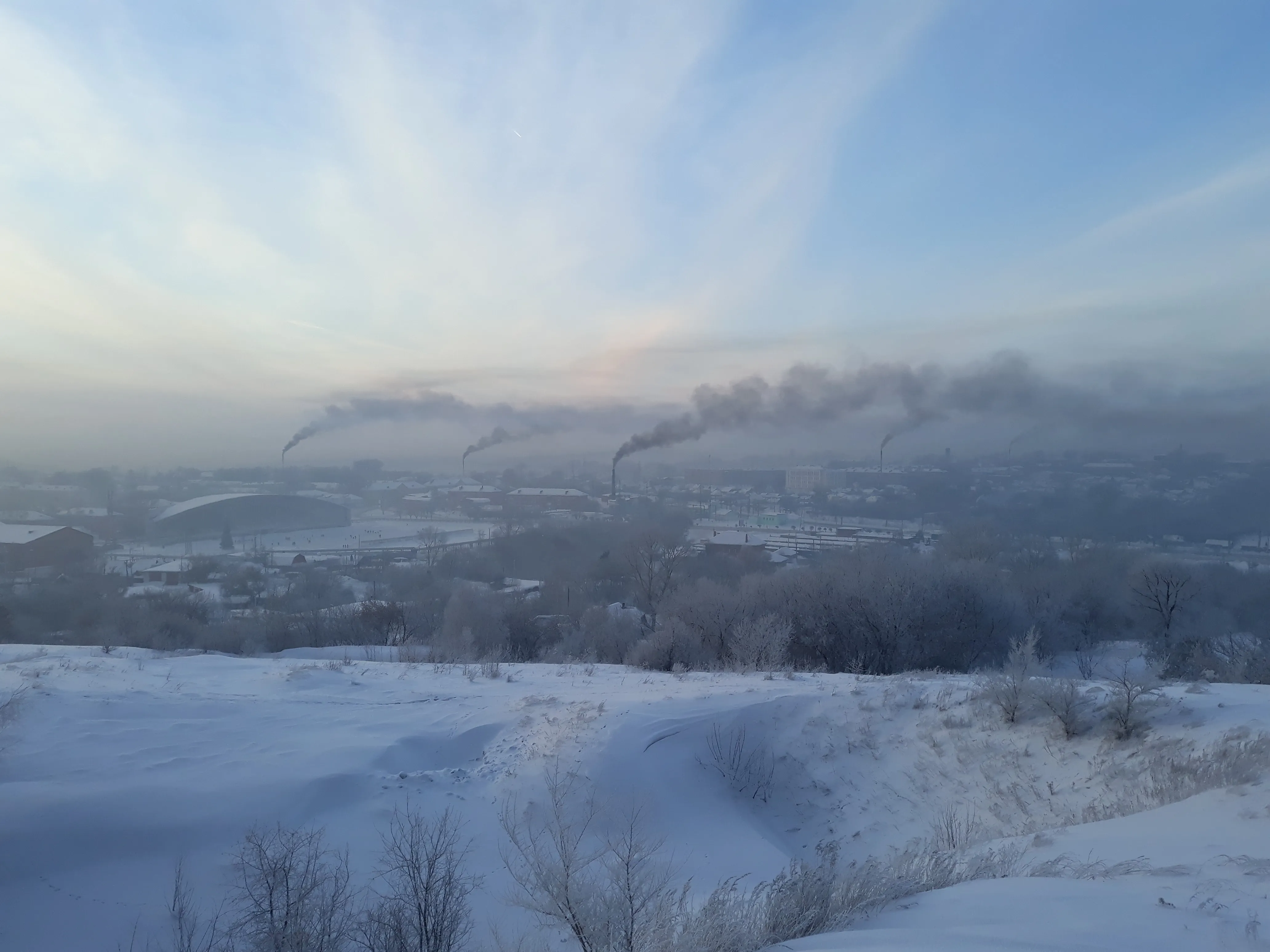 Panorama of Kiselyovsk in winter, with several visible plumes above the city